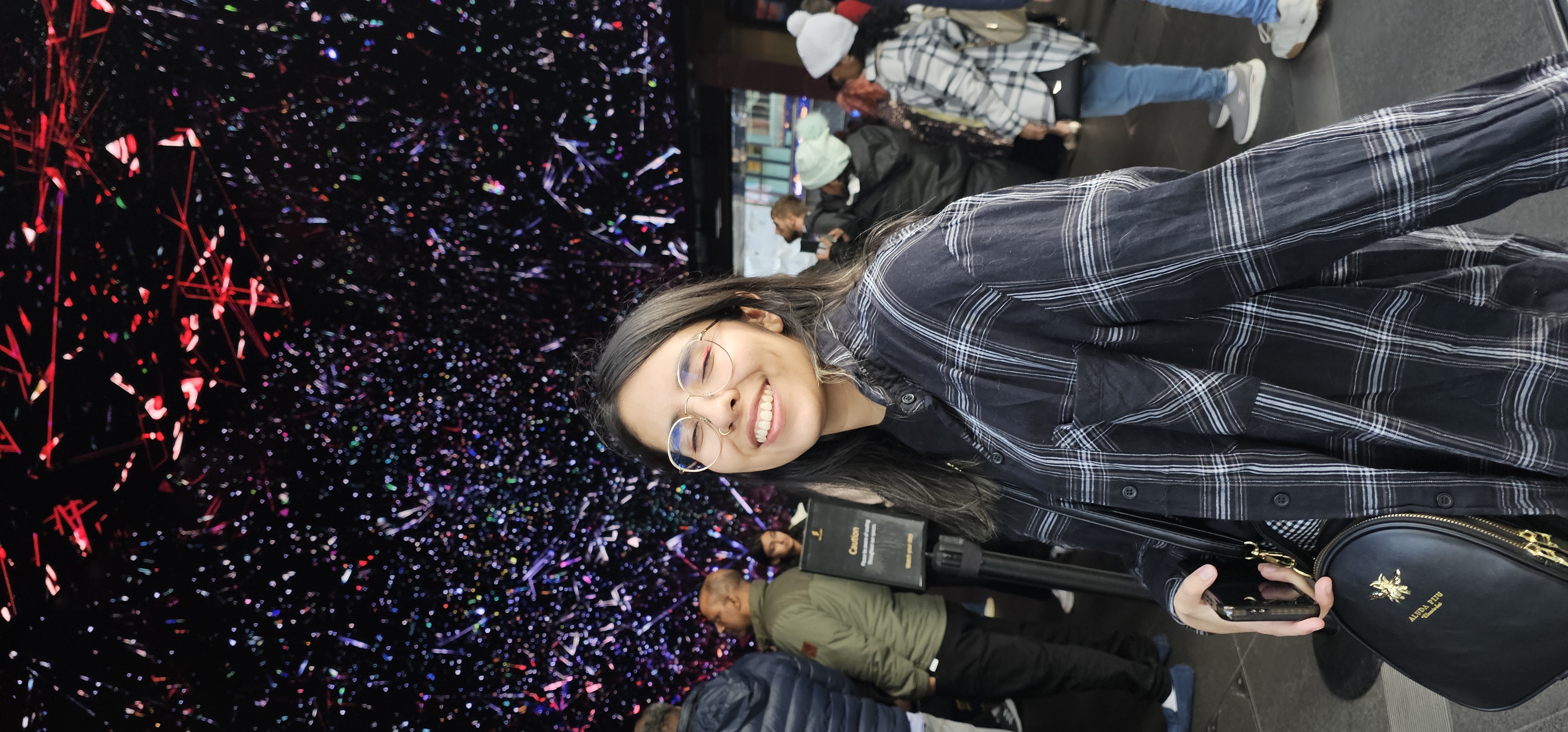 Picture of Sofi at a London art exhibition. There are several screens showing lots of colors and lights.